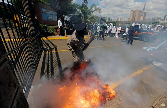 A tear gas canister fired by riot police explodes near a policeman as the police disperse doctors striking to demand fulfilment of a 2013 agreement between their union and the government that would raise their pay and improve working conditions outside Ministry of Health headquarters in Nairobi, Kenya December 5, 2016. (Photo by Thomas Mukoya/Reuters)