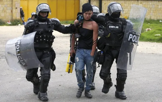 An anti-government protester is detained by police in Gachancipa, Colombia, Friday, May 7, 2021. The protests that began last week over a tax reform proposal continue despite President Ivan Duque's withdrawal of the tax plan on Sunday, May 2. (Photo by Ivan Valencia/AP Photo)