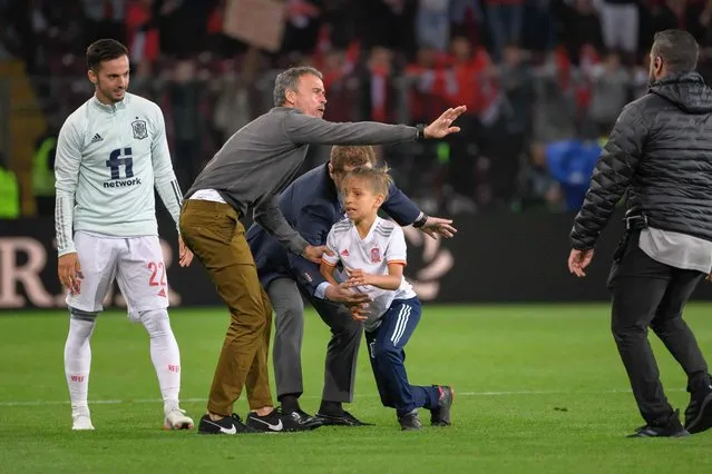 Spain's coach Luis Enrique (C) gestures to stops a security guard after a child entered the pitch to request a jersey of a Spanish player at the end of the UEFA Nations League - League A Group 2 football match between Switzerland and Spain at the Stade de Geneve in Geneva, on June 9, 2022. (Photo by Fabrice Coffrini/AFP Photo)