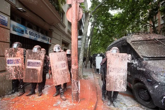 Riot police on guard as people throw paint and objects against them as they protest against the eviction of an occupied dwelling at a building called Bloc Llavors in Poble Sec neighborhood in Barcelona, Spain, 25 May 2021. (Photo by Marta Perez/EPA/EFE)