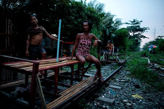 This picture taken on October 19, 2018 shows “trolley boy” couple Tyson Aguha (L) and Joan Acebo waiting for passengers along a train track in Manila, Philippines. (Photo by Noel Celis/AFP Photo)