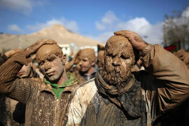 Iranian Shiites cover themselves with mud during Ashoura, marking the death anniversary of Imam Hussein, the grandson of Islam's Prophet Muhammad, at the city of Bijar, west of the capital Tehran, Iran, Thursday, November 14, 2013. Hussein, one of Shiite Islam's most beloved saints, was killed in a 7th century battle at Karbala, Iraq. (Photo by Ebrahim Noroozi/AP Photo)