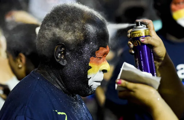 A drummer holds still for his face paint ahead of “Las llamadas” carnival parade in Montevideo, Uruguay, Friday, February 5, 2016. Las Llamadas, or “The Calls” is a drum-call parade with pounding Afro-Uruguayan rhythmic music known as Candombe. Its roots can be traced back to colonial times in Uruguay when African slaves were brought to South America. (Photo by Matilde Campodonico/AP Photo)