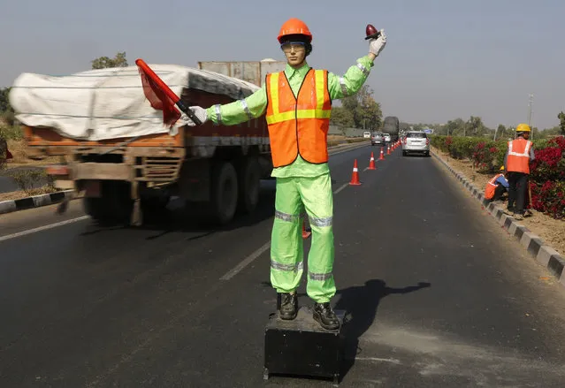 A robotic flagman signals to maintain traffic during the maintenance and repairs on the Ahmedabad-Delhi national highway on the outskirts of Ahmedabad, India, February 9, 2016. (Photo by Amit Dave/Reuters)