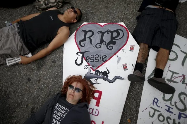 People stage a “die-in” in the middle of the road after carrying cutouts of coffins during a march to commemorate the more than 617 people they say have been killed by law enforcement in LA County since 2000, in Los Angeles, California April 7, 2015. (Photo by Lucy Nicholson/Reuters)
