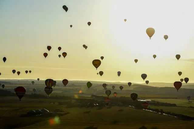 Around 320 hot-air balloons become airborne over the Chambley-Bussieres airbase, during the 17th international hot air balloon meeting “Grand-Est Mondial Air Ballons” in Hageville, northeastern France, on July 25, 2021. (Photo by Jean-Christophe Verhaegen/AFP Photo)