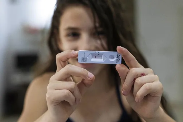 Ariel Kahana, 10, shows her COVID-19 Antigen test result, ahead of the first day of school, at her home in Moshav Talmey Yafe, Israel, Tuesday, August 31, 2021. (Photo by Tsafrir Abayov/AP Photo)