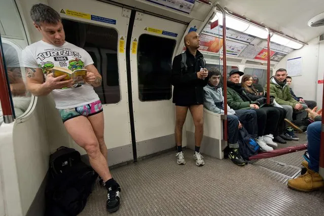 Participants in the13th annual International “No Pants Subway Ride” travel on a London underground train in London, on January 12, 2014. (Photo by Leon Neal/AFP Photo)