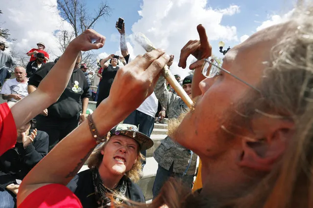 Partygoers listen to music and smoke marijuana on one of several days of the annual 4/20 marijuana festival, in Denver's downtown Civic Center Park, Saturday April 18, 2015. (Photo by Brennan Linsley/AP Photo)
