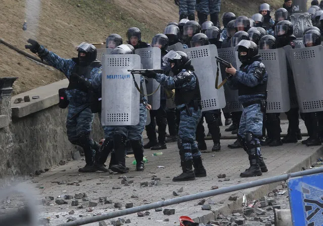 Ukrainian Riot police officers shoot rubber bullets and throw a stun grenade at anti-government protesters, on January 20, 2014. (Photo by Sergei Grits/AP Photo)