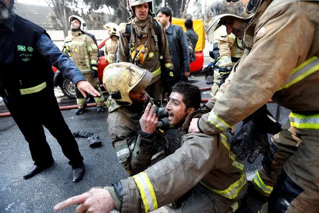 Iranian fire fighters condole one of their colleagues in Tehran, Iran, 19 January 2017. Media reported that major commercial building in Tehran has collapsed after hours of a severe fire, according to Iranian state media. At least 30 deaths, all firefighters were trapped on upper floors of buildings that have collapsed. (Photo by Abedin Taherkenareh/EPA)