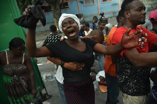 A mother cries beside the body of her dead son who was shot during clashes between Haitian police and demonstrators near to the National Palace in Port-au-Prince, on February 9, 2019. Demonstrators are demanding the resignation of Haitian President Jovenel Moise and protesting the Petrocaribe fund which for years Venezuela supplied Haiti and other Caribbean and Central American countries with oil at cut-rate prices and on easy credit terms. But investigations by the Haitian Senate in 2016 and 2017 concluded that nearly $2 billion from the program was misused. (Photo by Héctor Retamal/AFP Photo)