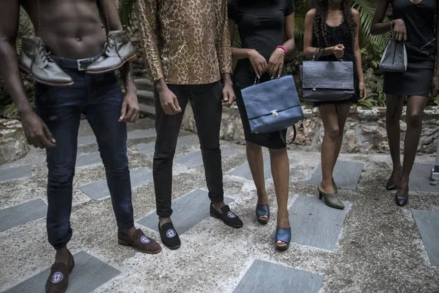 Models pose for a photo holding leather handbags created by a Haitian designer, in Port-au-Prince, Haiti, Sunday, September 26, 2021. (Photo by Rodrigo Abd/AP Photo)