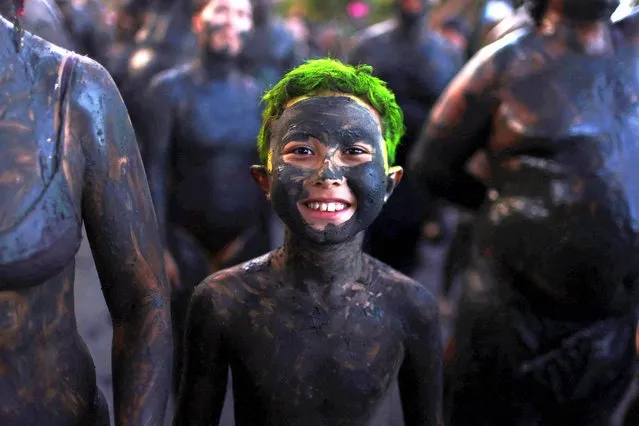 A boy attends the “Bloco da Lama” (Block of Mud) group during the carnival festivities, in Paraty, Brazil on February 11, 2024. (Photo by Pilar Olivares/Reuters)