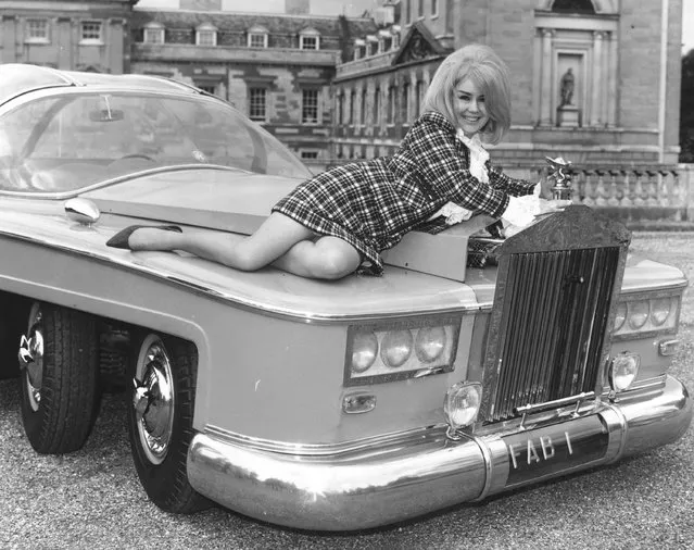 Actress Penny Snow reclines on the bonnet of a pink, six-wheeled Rolls Royce outside Woburn Abbey. The car is a specially built, full-size replica of the vehicle “FAB 1” owned by the character Lady Penelope in the puppet television series “Thunderbirds”. 1968. (Photo by Joe Bangay/Express/Getty Images)