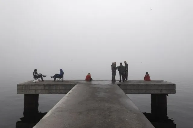 People on a pier near the Bosphorus on a foggy day in Istanbul, Turkey, 06 November 2021. (Photo by Erdem Sahin/EPA/EFE)