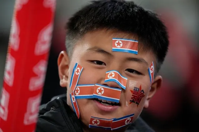 A fan has pasted North Korean flags on his face ahead of the FIFA World Cup 2026 and AFC Asian Cup 2027 preliminary joint qualification round 2 match between Japan and North Korea at the National Stadium Thursday, March 21, 2024, in Tokyo. (Photo by Eugene Hoshiko/AP Photo)