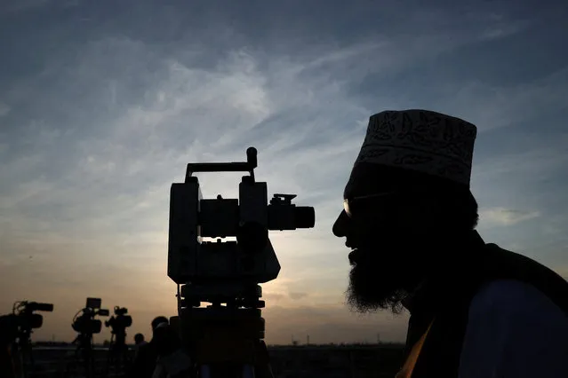 A member of Pakistan's moon sighting committee is silhouetted as he uses theodolite to look for the new moon as Muslims attend an evening prayer session called “Tarawih” to mark the holy fasting month of Ramadan in Peshawar, Pakistan on March 11, 2024. (Photo by Fayaz Aziz/Reuters)