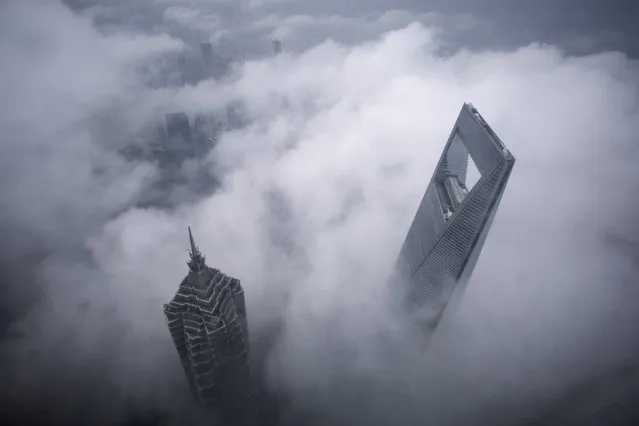 Skyscrapers Shanghai World Financial Center (R) and Jin Mao Tower are seen during heavy rain at the financial district of Pudong in Shanghai May 15, 2015. (Photo by Aly Song/Reuters)