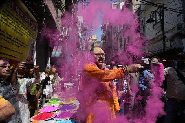 A Hindu man sprays coloured powder as people celebrate Holi, the Hindu festival of colors, in Jammu, India, Monday, March. 25, 2024. (Photo by Channi Anand/AP Photo)