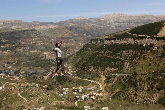 Lebanese Gino Traboulsi walks on a tightrope over the valley of Afqa, northeast of the capital Beirut, on April 3, 2016. (Photo by Patrick Baz/AFP Photo)