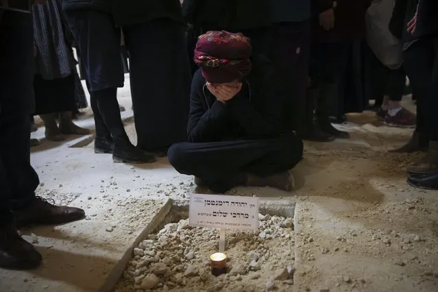 Atiya, wife of Yehuda Dimentman, who was killed in a Palestinian shooting attack, mourns next to his grave, during his funeral in Givat Shaul cemetery in Jerusalem, Friday, December 17, 2021. (Photo by Oren Ziv/AP Photo)