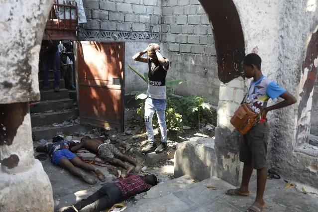 People look at the the bodies of three persons shot dead after an overnight shooting in the Pétion Ville neighborhood of Port-au-Prince, Haiti, Monday, April 1, 2024. (Photo by Odelyn Joseph/AP Photo)