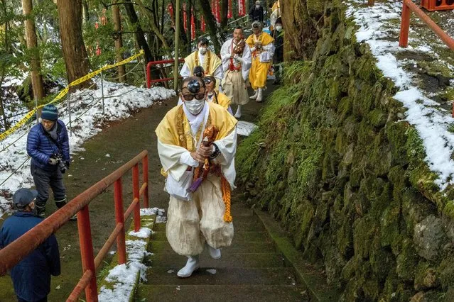Mountain priests (Yamabushi) climb stone steps after pray front of the waterfall during a Fudo honor festival on January 03, 2022 in Tambasasayama, Japan. The Yamabushi chant and pray as worshipers walk barefoot on the burnt logs and wish for good health and happiness in the new year. Due to the coronavirus pandemic the event was canceled last year. (Photo by Buddhika Weerasinghe/Getty Images)