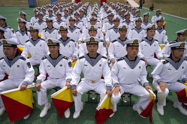 Chinese sailors holding flags used for signaling during a tour arranged for foreign journalists, a day before the opening of the West Pacific Naval Symposium in Qingdao in eastern China's Shandong province, Sunday, April 21, 2024. Established in 1953, the Academy has trained more than 100,000 naval officers and sailors for the Chinese navy and over 80 percent of submarine staff graduate or were trained here, according to China's official People's Daily. (Photo by Ng Han Guan/AP Photo)