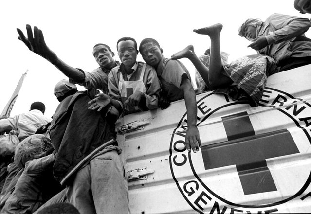 Rwandan refugees try to board a bus in Sake to transport them to the border; 1996. (Photo by Carol Guzy/The Washington Post)