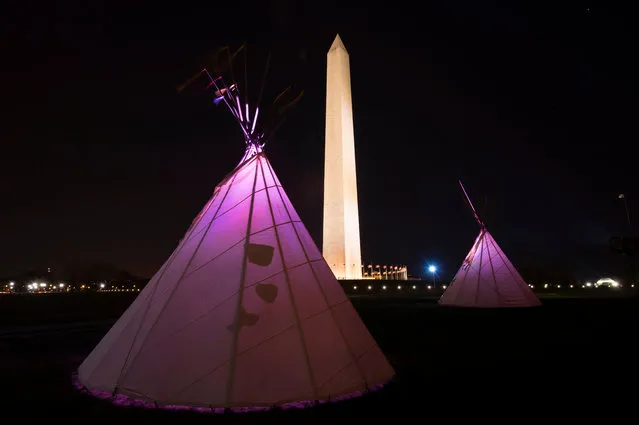 Native American teepees are seen on the National Mall in downtown Washington, DC on March 8, 2017, with the National Monument to the rear as tribes from around the US gather for four days of protest against the Trump administration and the Dakota Access oil pipeline. (Photo by Paul J. Richards/AFP Photo)