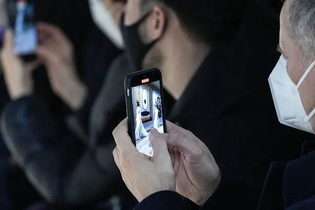 Audience members record on their cell phones models wearing creations for the Dior Spring-Summer 2022 Haute Couture fashion collection collection, in Paris, Monday, January 24, 2022. (Photo by Michel Euler/AP Photo)