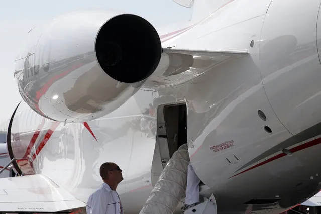 Employees check the cooling system of a Dassault Falcon 900LX during the Paris Air Show, at Le Bourget airport, north of Paris, Tuesday, June 16, 2015. Some 300,000 aviation professionals and spectators are expected at this week's Paris Air Show, coming from around the world to make business deals and see dramatic displays of aeronautic prowess and the latest air and space technology. (AP Photo/Francois Mori)