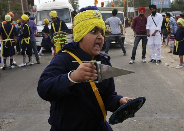 A Sikh boy reacts as he displays martial art skills during a religious procession ahead of the Baisakhi festival on the outskirts of Jammu April 13, 2014. (Photo by Mukesh Gupta/Reuters)