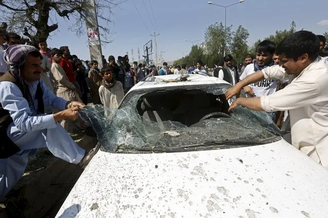Afghan men remove the broken window of a car at the site of a suicide bomb attack in Kabul, Afghanistan, June 30, 2015. (Photo by Omar Sobhani/Reuters)