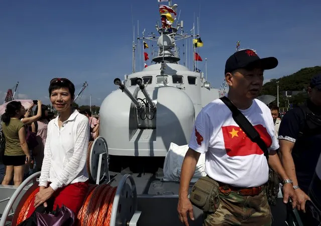 A visitor wearing a t-shirt featuring a Chinese national flag walks on a naval ship at a People's Liberation Army naval base in Hong Kong July 1, 2015. (Photo by Bobby Yip/Reuters)