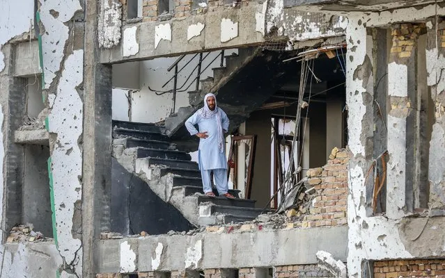 An Afghan man stands on the middle of residential ruined building, in Kabul, Afghanistan, 29 July 2019, a day after a complex suicide attack followed by a fire fight against the office of Afghan former chief of intelligence and current candidate as the first voice president of Ashraf Ghani, in Kabul. According to reports, at least 20 people were killed and 50 others wounded in the incident which targeted the office of Amrullah Saleh. (Photo by Hedayatullah Amid/EPA/EFE/Rex Features/Shutterstock)