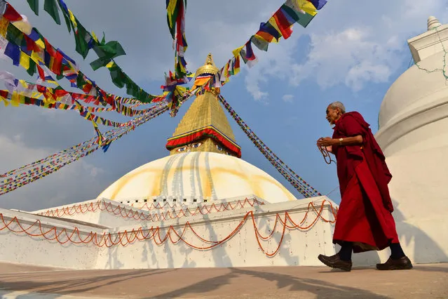 A Buddhist monks circles Boudhanath Stupa on the outskirts of Kathmandu on March 24, 2017. Boudhanath Stupa was among hundreds of historic monuments damaged during the 7.8-magnitude quake that hit Nepal in April 2015, killing nearly 9,000 people. The stupa has been reopened following renovation after earthquake damage. (Photo by Prakash Mathema/AFP Photo)