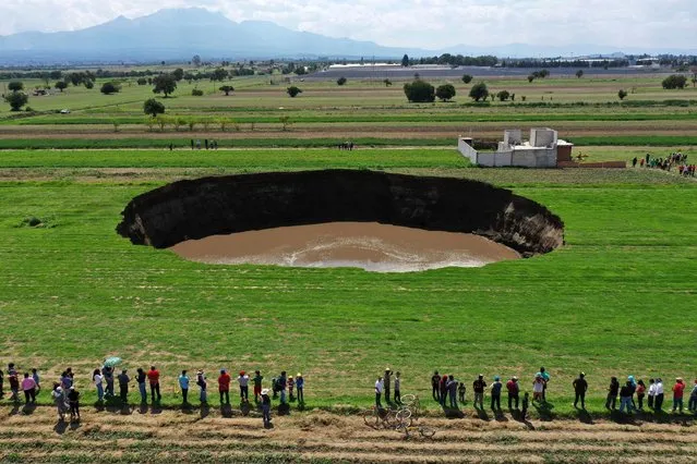 Aerial view of a sinkhole that was found by farmers in a field of crops in Santa Maria Zacatepec, state of Puebla, Mexico on May 30, 2021. (Photo by Jose Casta-Ares/AFP Photo)