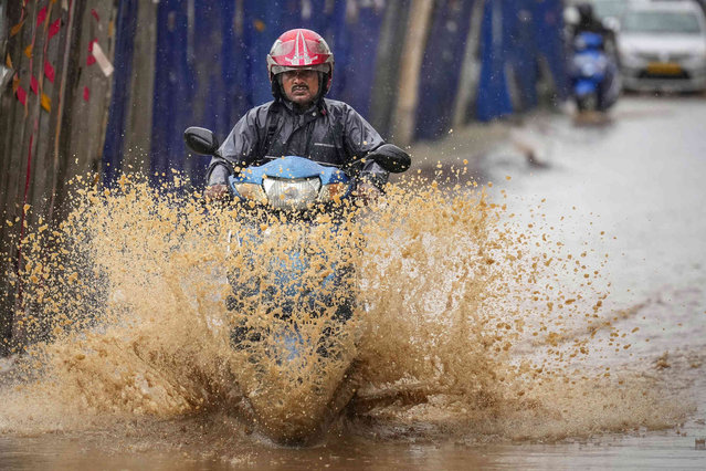 A person drives through a flooded street after heavy monsoon rains in Guwahati, India, Wednesday, June 5, 2024. (Photo by Anupam Nath/AP Photo)