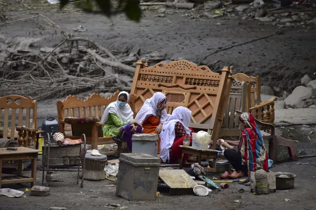 A Pakistani Kashmiri family gather around their belongings outside their damaged house following heavy monsoon rains in Neelum valley, near the Line of Control in Pakistan-controlled Kashmir on July 16, 2019. In Pakistan-administered Kashmir, officials said at least 23 people were killed after heavy rain triggered flash floods and damaged more than 120 houses and 30 shops, while crippling the water and electricity supplies. (Photo by Sajjad Qayyum/AFP Photo)