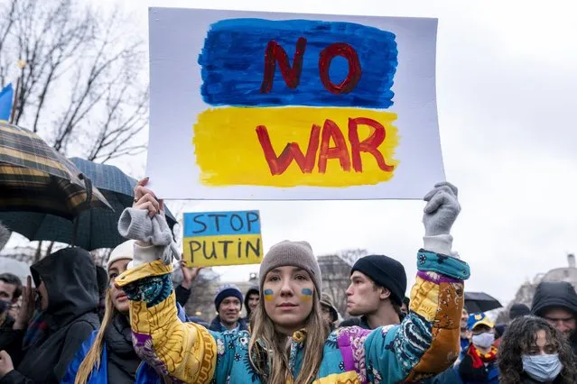 A tear rolls down through the colors of the Ukrainian flag on the cheek of Ukranian Oleksandra Yashan of Arlington, Va., as she becomes emotional while holding a sign that reads “No War” during a vigil to protest the Russian invasion of Ukraine in Lafayette Park in front of the White House in Washington, Thursday, February 24, 2022. (Photo by Andrew Harnik/AP Photo)