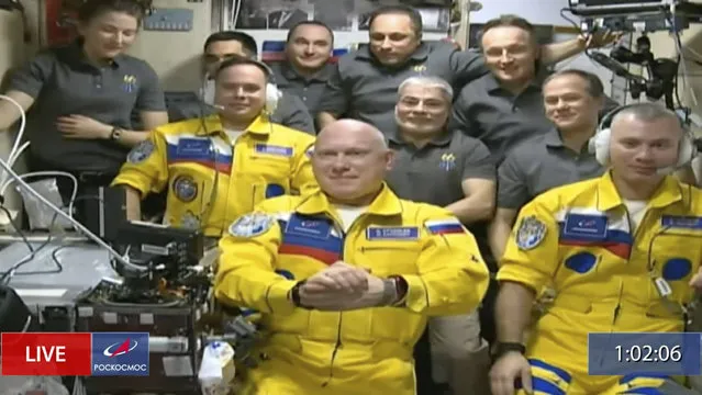 In this frame grab from video provided by Roscosmos, Russian cosmonauts Sergey Korsakov, Oleg Artemyev and Denis Matveyev are seen during a welcome ceremony after arriving at the International Space Station, Friday, March 18, 2022, the first new faces in space since the start of Russia’s war in Ukraine. The crew emerged from the Soyuz capsule wearing yellow flight suits with blue stripes, the colors of the Ukrainian flag. (Photo by Roscosmos via AP Photo)