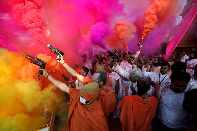 Hindu priests use colour smoke guns to celebrate Holi, the festival of colours, at a temple premises in Salangpur, in the western state of Gujarat, India on March 7, 2023. (Photo by Amit Dave/Reuters)