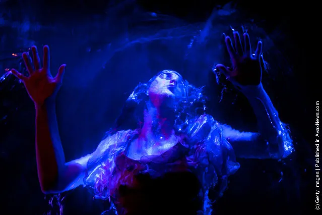 Artists preform on a pool suspended above the audience during the Fuerza Bruta dress rehearsal