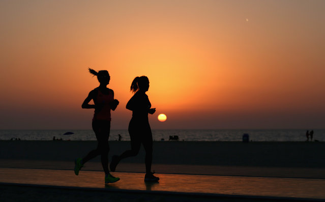 Runners jog along the recently refurbished Kite Beach is pictured on September 14, 2015 in Dubai, United Arab Emirates. The Beach is very popular with Dubai locals, with a variety of water sports and refreshments on offer.  (Photo by Warren Little/Getty Images)