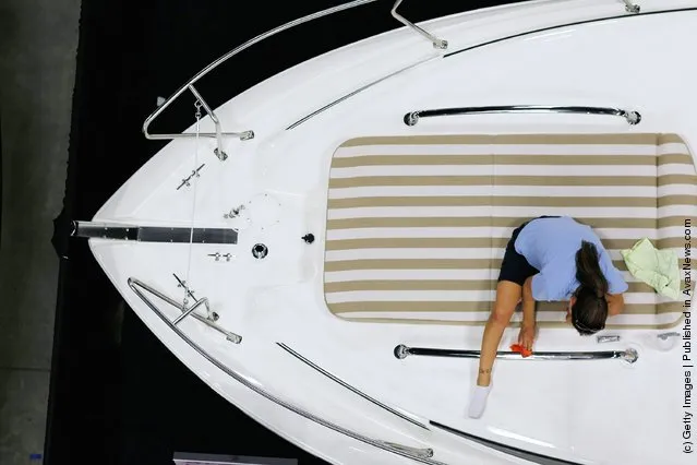 Workers prepare boats for tomorrow's opening day of the four day long Progressive Insurance Miami International Boat Show at the Miami Beach Convention Center