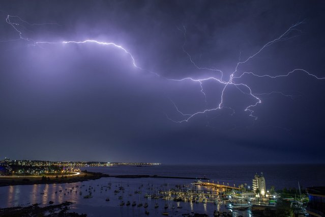 A lightning strikes during a thunderstorm in Montevideo on March 12, 2024. (Photo by Mariana Suarez/AFP Photo)