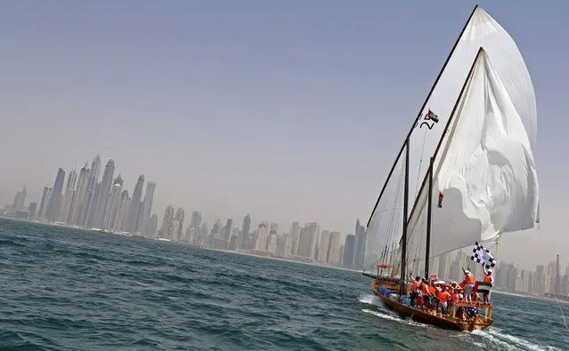 The crew of Zilzal, a dhow captained by Sheikh Hamdan bin Mohammad bin Rashid al-Maktoum, sails towards the finishing line off the coast of Dubai to win al-Gaffal traditional long-distance dhow sailing race which started at the island of Sir Bu Nair in the Gulf, on May 14, 2017. (Photo by Karim Sahib/AFP Photo)