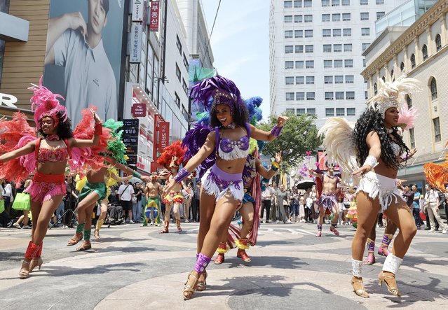 A samba dance group from the Lotte World Adventure theme park performs in Myeongdong shopping district of Seoul, South Korea, 19 June 2024. (Photo by Yonhap/EPA)